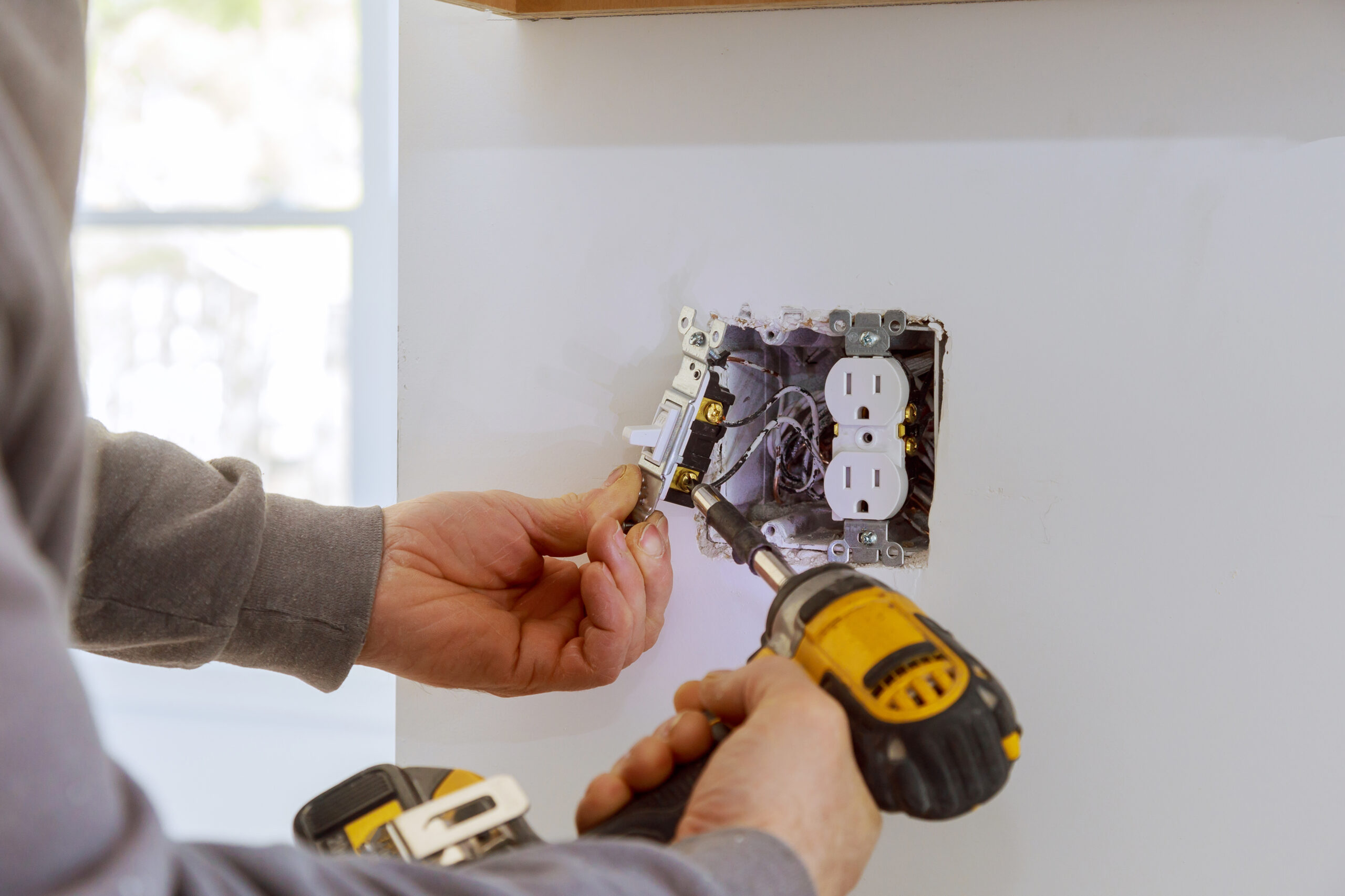 Work on installing electrical outlets with electrical wires and connector installed in plasterboard drywall